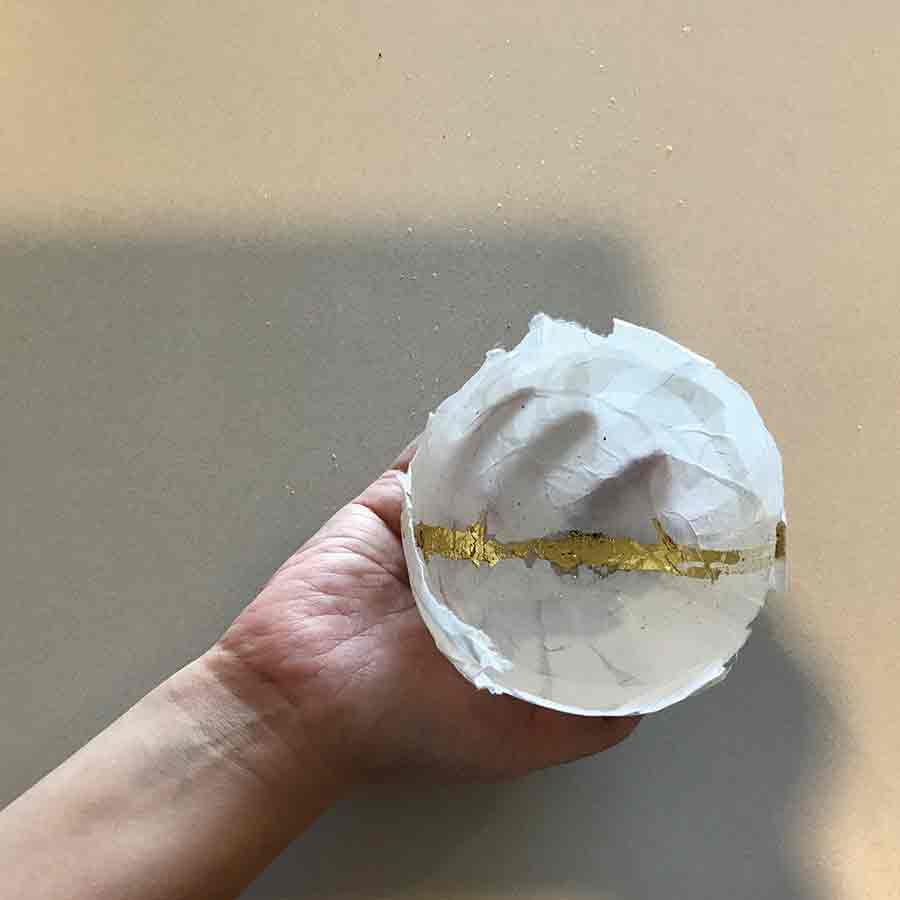 Right hand of an oncology nurse holding a paper mâché bowl she made as part of a grief and self-care process